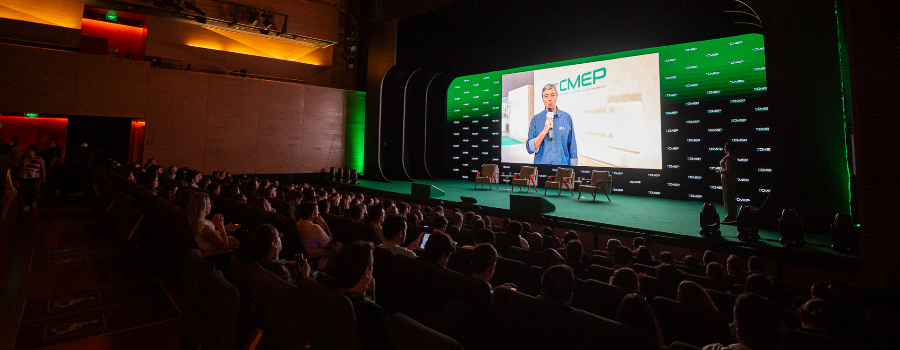 Palco do 18º CMEP – Congresso de Meios Eletrônicos de Pagamento, com auditório cheio e especialistas debatendo inovação no setor.